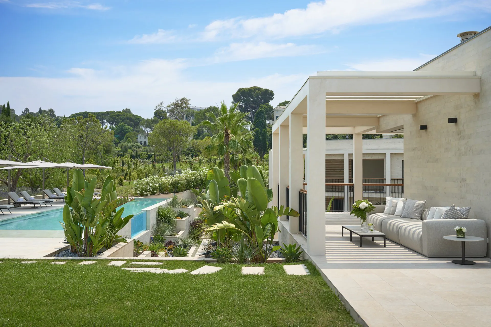 Domaine de la Belle Étoile villa exterior with outdoor terrace, covered lounge seating, pool and lush tropical gardens
