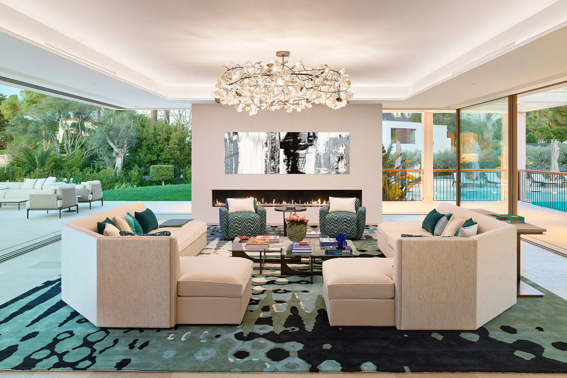 Spacious reception room at Domaine de la Belle Étoile with linear fireplace, cream sofas and floor-to-ceiling garden views