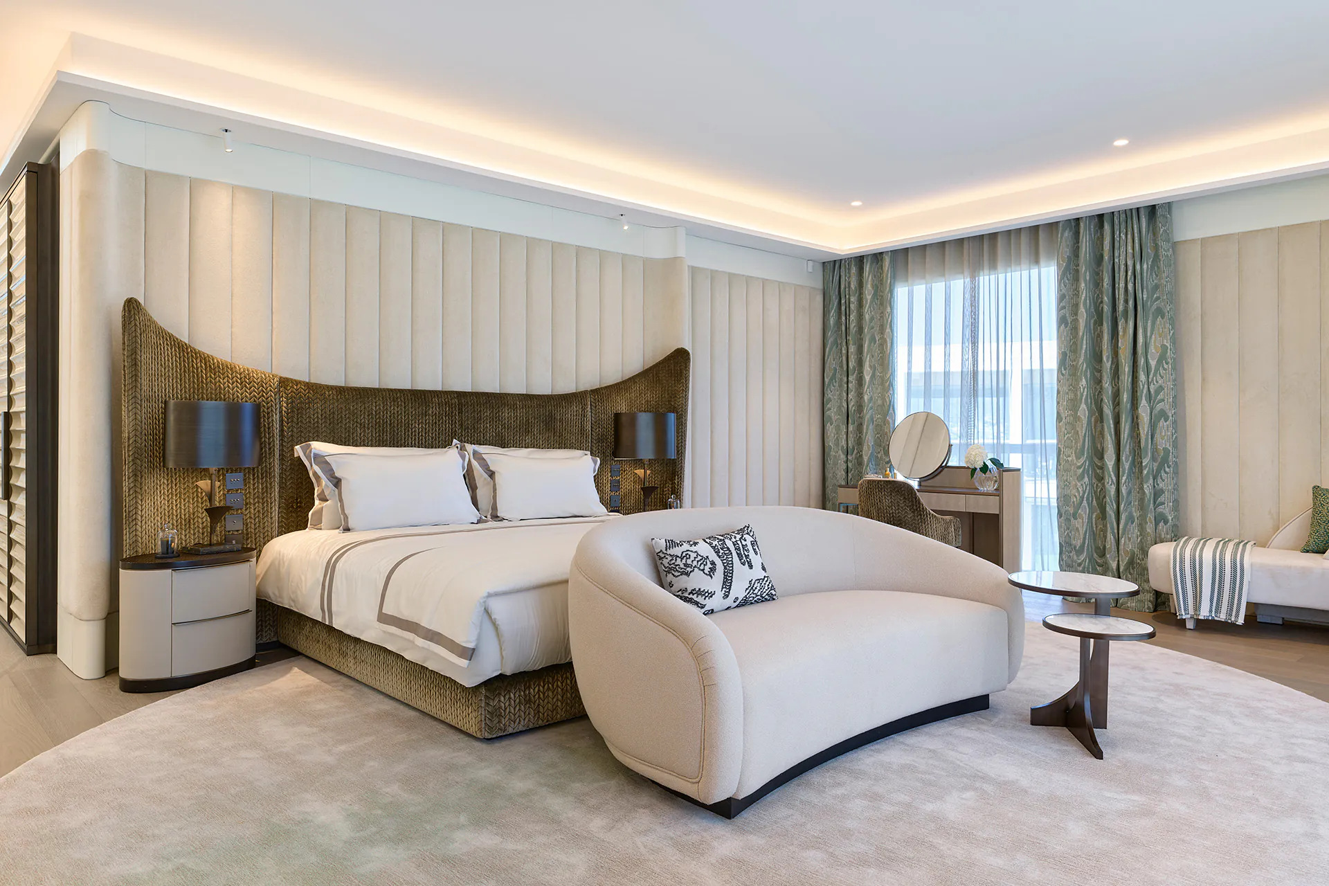 Luxury master bedroom suite at Domaine de la Belle Étoile with sculptural woven headboard, curved sofa and dressing table