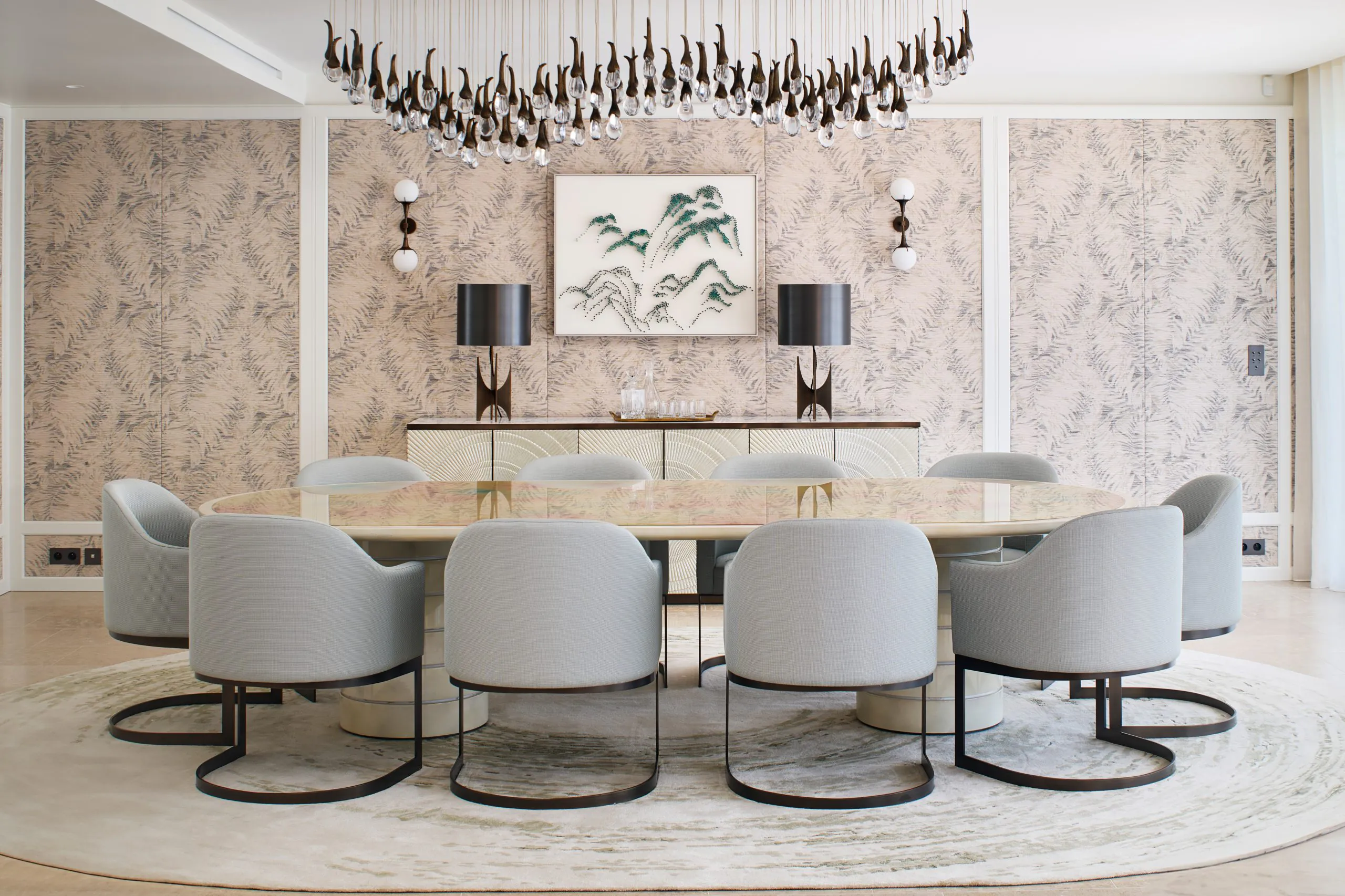 Formal dining room at Domaine de la Belle Étoile with oval stone table, upholstered chairs and sculptural chandelier