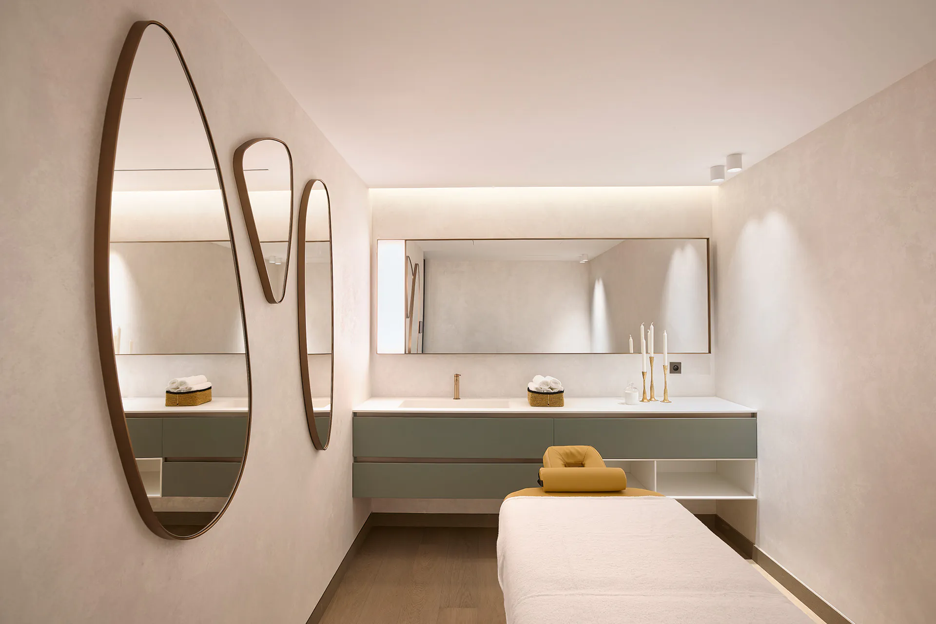 Private spa treatment room at Domaine de la Belle Étoile with massage table and sculptural bronze mirrors