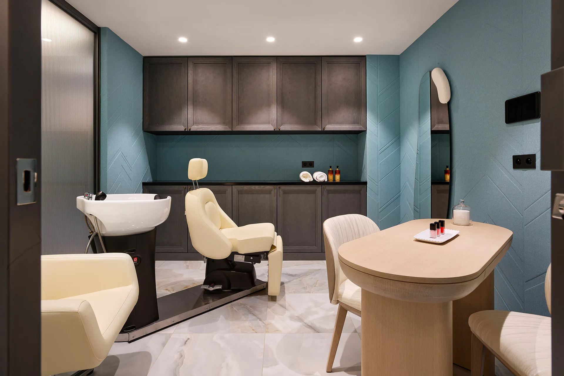 Private hair and beauty salon at Domaine de la Belle Étoile with wash chairs, teal walls and marble flooring