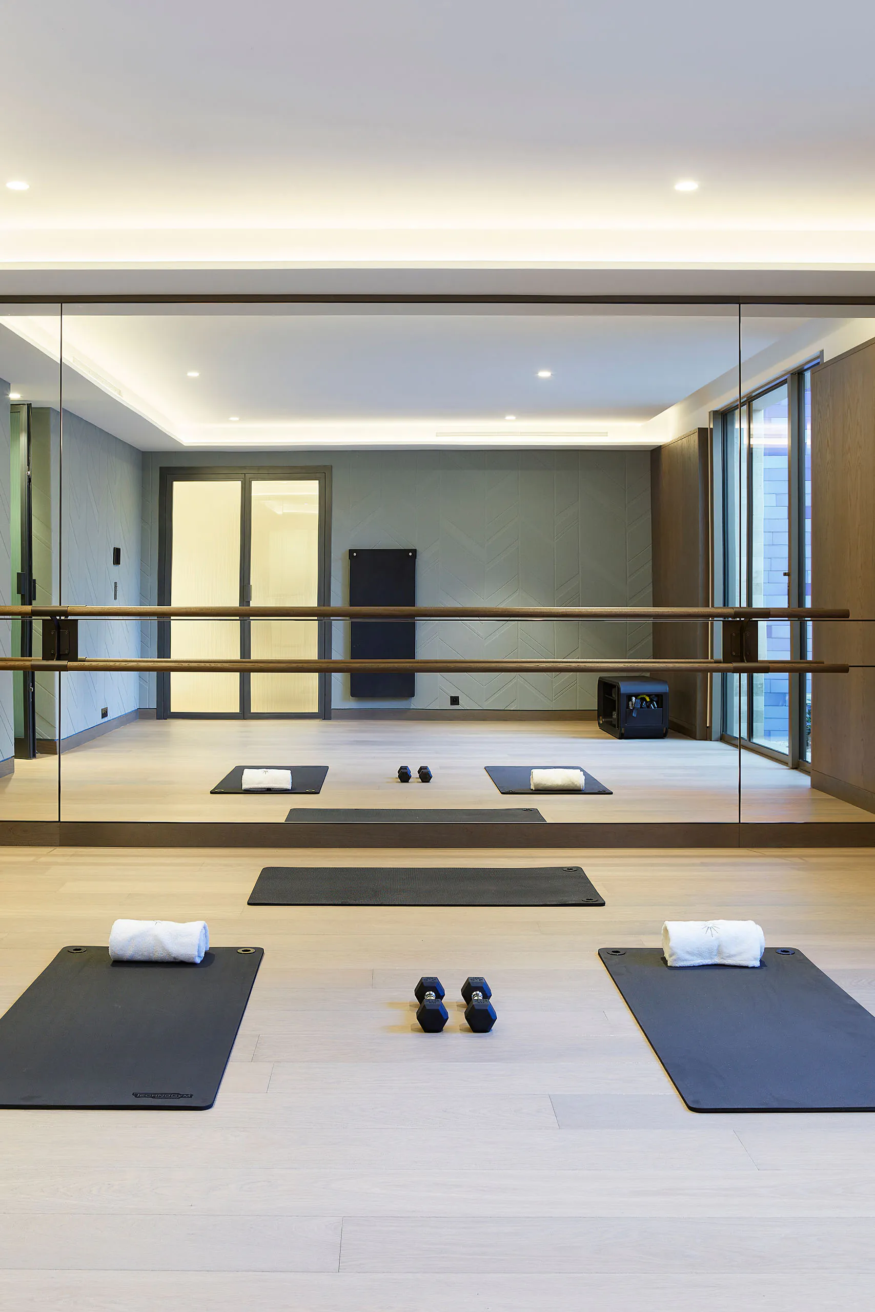 Private fitness studio at Domaine de la Belle Étoile with yoga mats, ballet barre and floor-to-ceiling mirrors